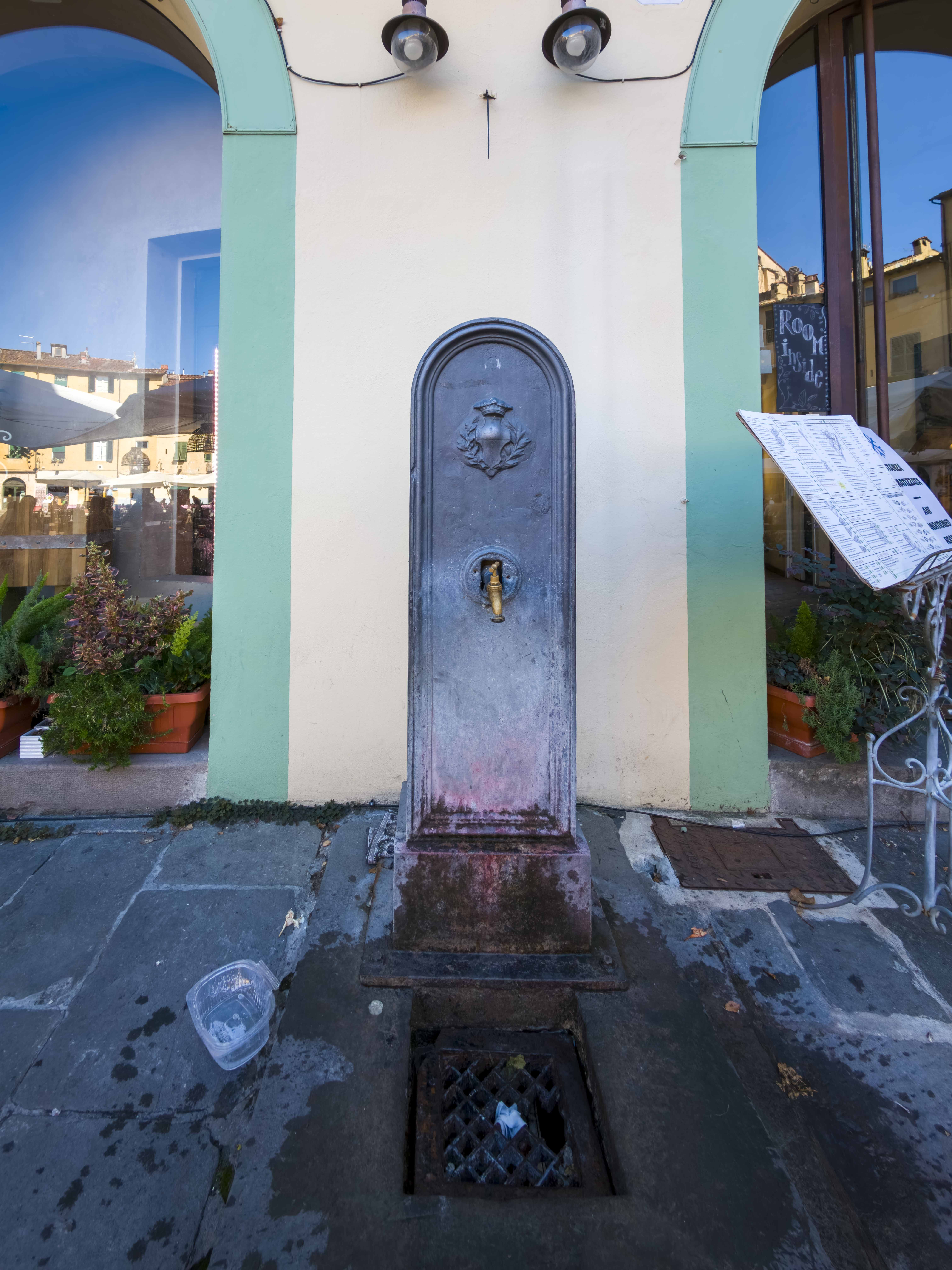 Fontanella pubblica storica con lo stemma di Lucca in un portico del centro storico